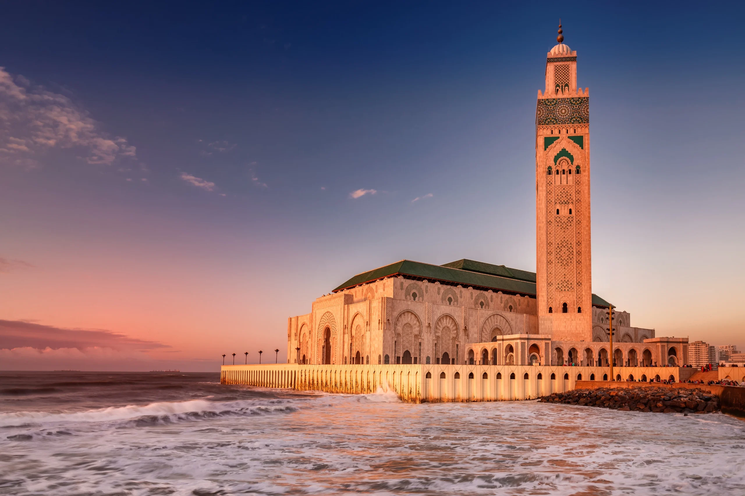 Vue sur la Mosquée Hassan II de Casablanca au coucher du soleil avec l’océan en arrière-plan